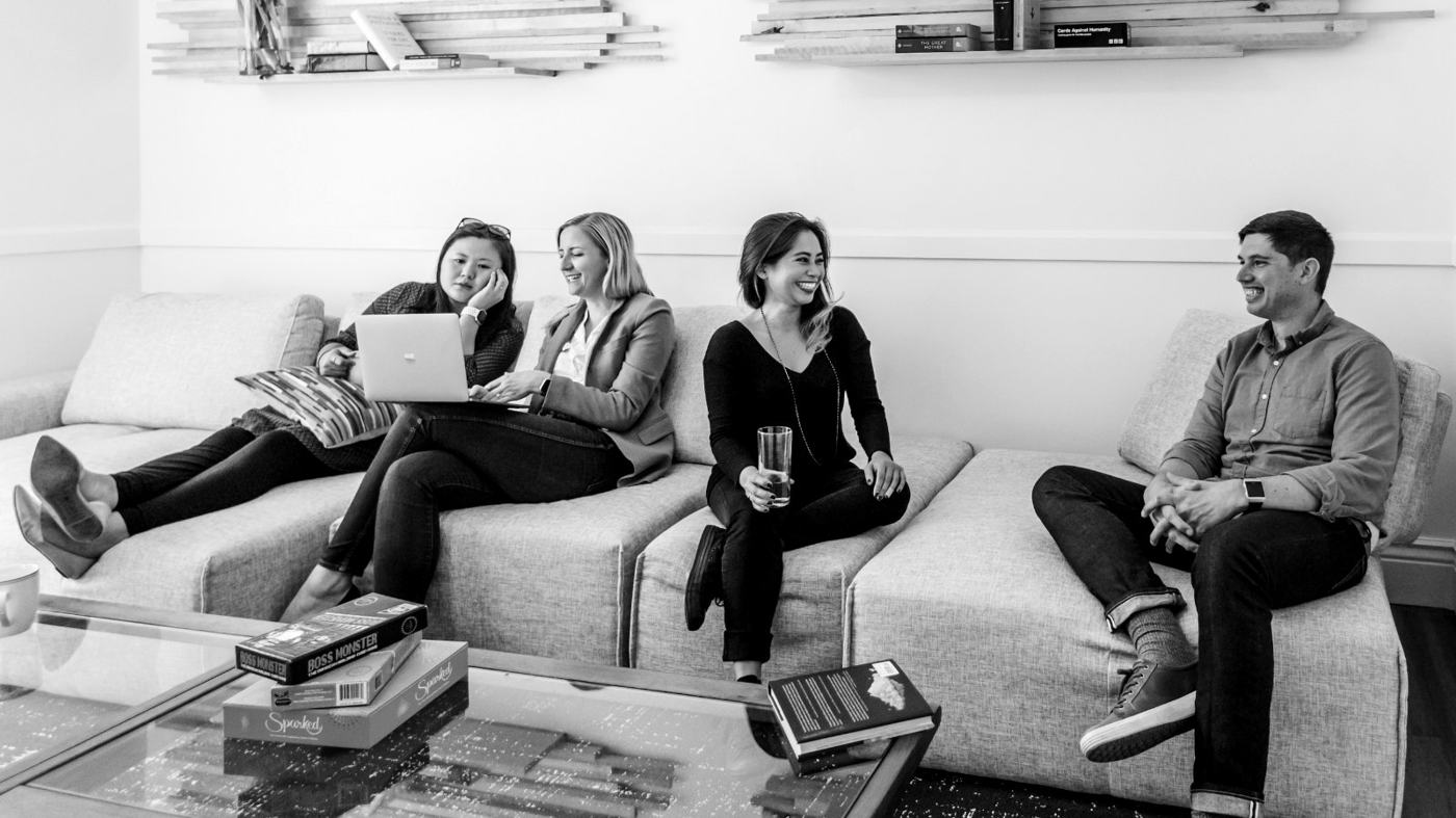 Black-and-white photo of residents relaxing together in a shared co-living lounge, illustrating why community, lifestyle and location matter in co-living